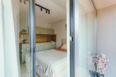 a bedroom with a bed and a sliding glass door at Kątowa Studio - Sauna, AC, balcony in Kraków