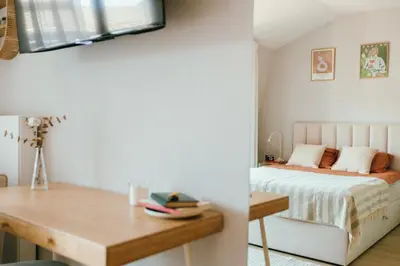 a bedroom with a bed and a wooden desk at Kątowa Studio - Sauna, AC, balcony in Kraków