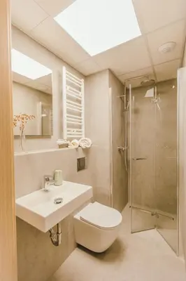a bathroom with a toilet and a sink and a shower at Kątowa Studio - Sauna, AC, balcony in Kraków