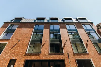 a tall red brick building with many windows at Kątowa Studio - Sauna, AC, balcony in Kraków