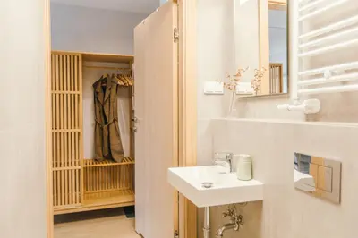 a white bathroom with a sink and a mirror at Kątowa Studio - Sauna, AC, balcony in Kraków