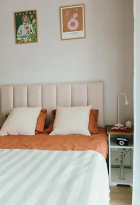 a bedroom with a bed with orange and white sheets at Kątowa Studio - Sauna, AC, balcony in Kraków