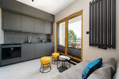a chair and a table in a living room at Bed&Bath Modern Old Town Apartments in Kraków
