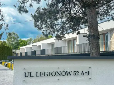 a white building with a tree on the side of it at SOLAPART Apartamenty in Oświęcim