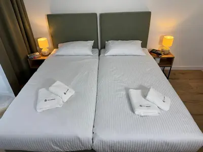 a large bed with two white towels on it at SOLAPART Apartamenty in Oświęcim