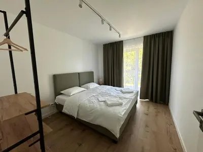 a bedroom with a bed and a large window at SOLAPART Apartamenty in Oświęcim