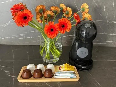a vase with orange flowers and a plate of chocolates next to at SOLAPART Apartamenty in Oświęcim