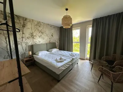 a bedroom with a bed and a large window at SOLAPART Apartamenty in Oświęcim