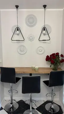 a kitchen with two chairs and a counter with three lights at Rivershine Apartment Cracow in Kraków