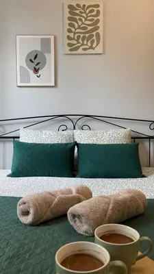 a bed with two cups of coffee on a table at Rivershine Apartment Cracow in Kraków