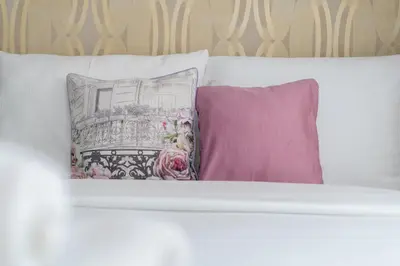 a white bed with three pillows on it at Grzegórzki Comfy Apartment by BookingHost in Kraków