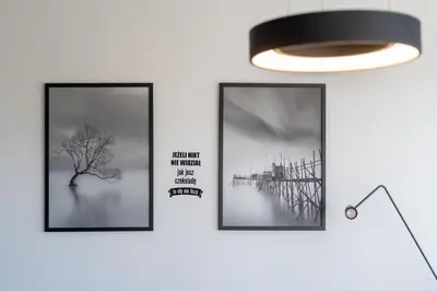 three framed pictures on a wall with a lamp at Grzegórzki Comfy Apartment by BookingHost in Kraków
