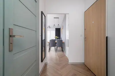 a hallway with a door and a dining room at Nowoczesny Apartament w Krakowie z Klimatyzowanym Salonem Dwa Miejsca Postojowe by Noclegi Renters in Kraków