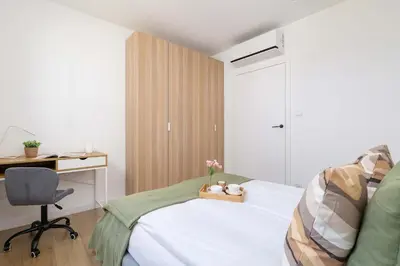 a bedroom with a bed and a desk and a chair at Nowoczesny Rodzinny Apartament z Klimatyzacją i Parkingiem w Krakowie by Renters Prestige in Kraków