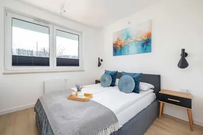 a bedroom with a bed and two windows at Nowoczesny Rodzinny Apartament z Klimatyzacją i Parkingiem w Krakowie by Renters Prestige in Kraków