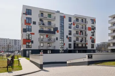 a tall white building with balconies in a parking lot at Nowoczesny Rodzinny Apartament z Klimatyzacją i Parkingiem w Krakowie by Renters Prestige in Kraków