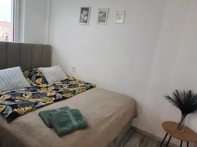 a bedroom with a bed with a green blanket at Perfekt Place in Oświęcim