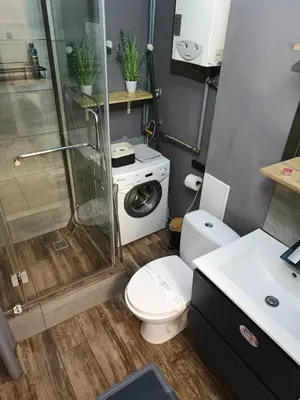 a bathroom with a shower toilet and a washing machine at Perfekt Place in Oświęcim