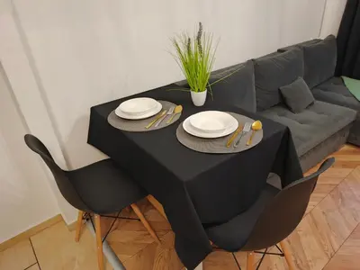 a black table with two chairs and a couch at Perfekt Place in Oświęcim