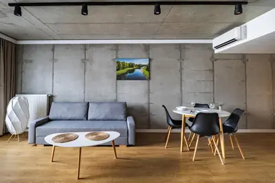 a living room with a couch and a table at Loft Place Oswiecim - Air Conditioning, City Center, Self Check-in in Oświęcim