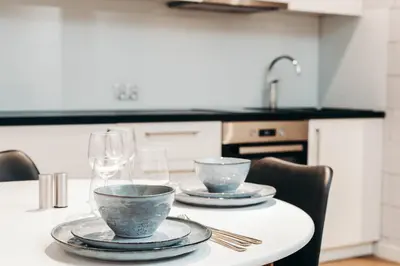 a table with two plates and wine glasses on it at Loft Place Oswiecim - Air Conditioning, City Center, Self Check-in in Oświęcim