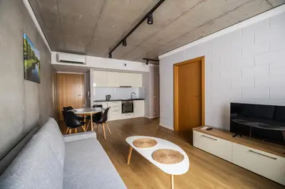 a living room with a couch and a table at Loft Place Oswiecim - Air Conditioning, City Center, Self Check-in in Oświęcim