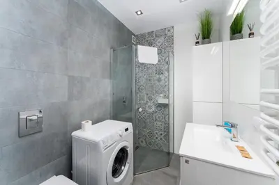 a bathroom with a washing machine and a sink at Podłęska Comfort Apartment by BookingHost in Kraków