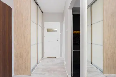 a hallway with white walls and glass doors at Podłęska Comfort Apartment by BookingHost in Kraków