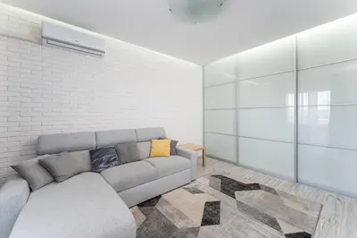 a living room with a couch and a brick wall at Podłęska Comfort Apartment by BookingHost in Kraków