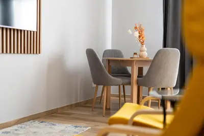 a dining room table with three chairs and a vase on it at Noble Residence Luxury Suites in Kraków