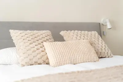 a bed with white sheets and pillows on it at Noble Residence Luxury Suites in Kraków