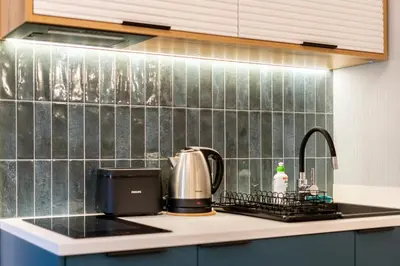a kitchen counter with a coffee maker and a sink at Blue Den Old Town Apartments in Kraków
