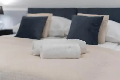 a stack of white towels on a bed at Blue Den Old Town Apartments in Kraków