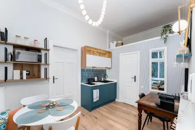 a kitchen and dining room with a table and chairs at Blue Den Old Town Apartments in Kraków
