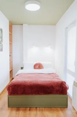 a white bedroom with a bed with a red blanket at Apartament 2A na ul Wiejskiej 32c in Oświęcim