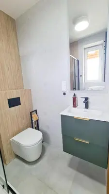 a bathroom with a toilet and a sink and a mirror at Apartament 2A na ul Wiejskiej 32c in Oświęcim