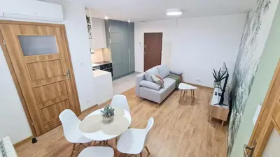 a living room with a couch and a table and chairs at Apartament 2A na ul Wiejskiej 32c in Oświęcim