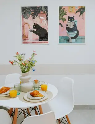 a table with plates of food and a black cat at Apartament 3A na ul Wiejskiej 32c in Oświęcim