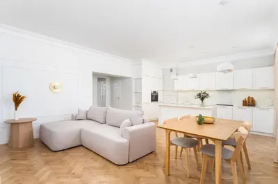 a white living room with a couch and a table at Parkside Family Suite in Kraków