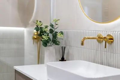 a bathroom with a sink and a mirror and flowers at Parkside Family Suite in Kraków