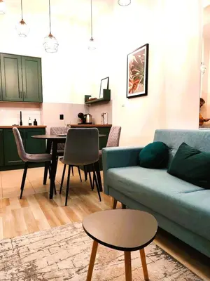 a living room with a blue couch and a table at Old Town Apartments - Kingi Street in Kraków