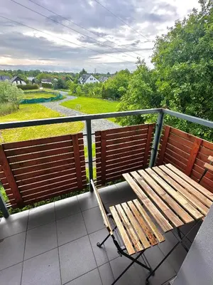 a wooden bench sitting on a balcony with a view at Apartament Nad Stawem in Wadowice