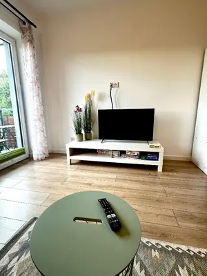 a living room with a table and a television at Apartament Nad Stawem in Wadowice