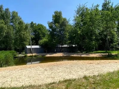 a field with a house in the middle of a river at Apartament Nad Stawem in Wadowice