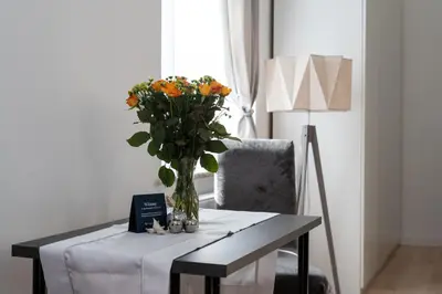 a table with a vase of flowers on it at Malila Premium Apartments Cracow Świętego Łazarza 3 in Kraków