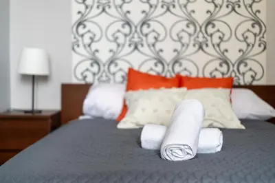 a bed with two rolls of paper towels on it at Malila Premium Apartments Cracow Świętego Łazarza 3 in Kraków