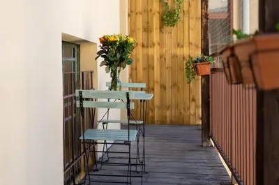 a table and chairs with a vase of flowers on a porch at Malila Premium Apartments Cracow Świętego Łazarza 3 in Kraków