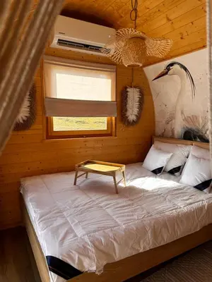 a bedroom with a bed with a table on it at Raj na Hektarach in Wysokie