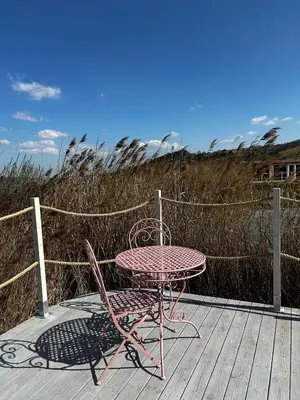 a pink table and chair sitting on a wooden deck at Raj na Hektarach in Wysokie