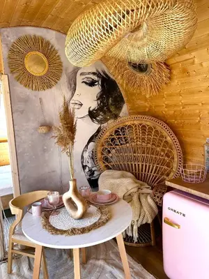a table with a vase on it in front of a painting at Raj na Hektarach in Wysokie